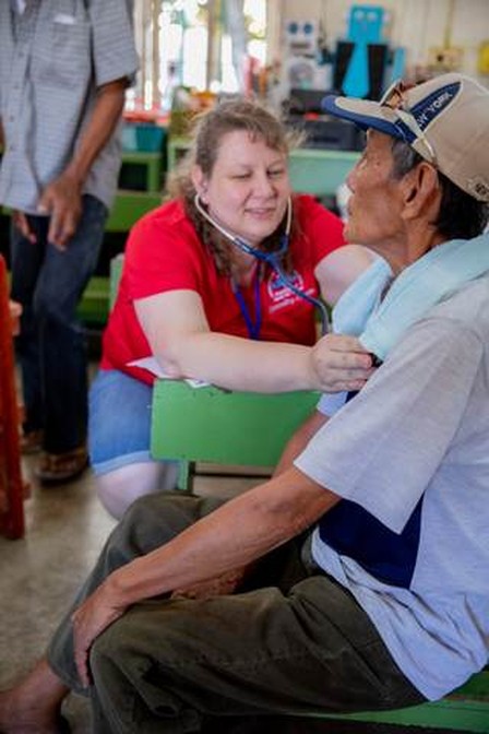 A volunteer checks a patient’s heart in a clinic.